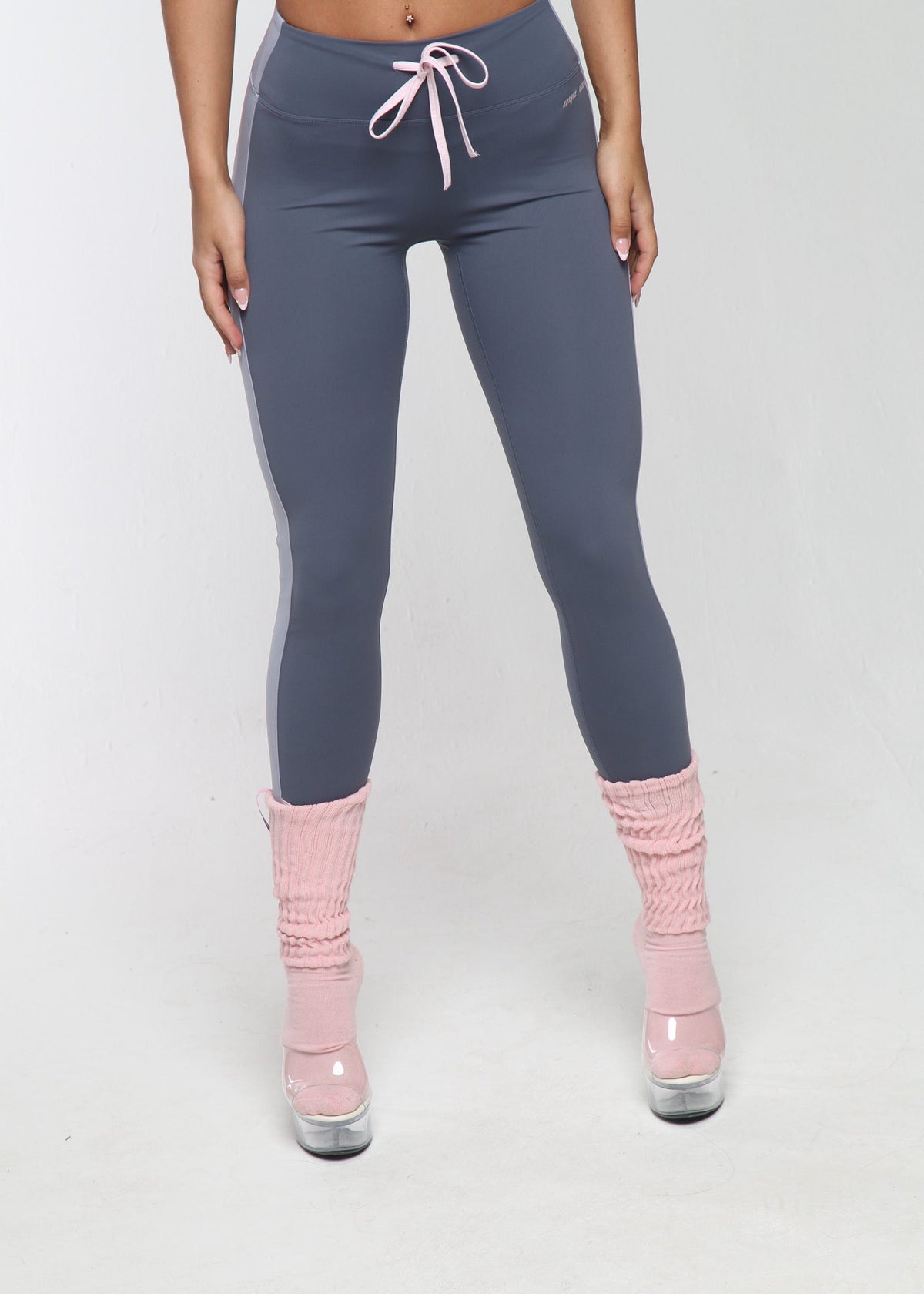 Person wearing gray leggings and pink socks on a white background