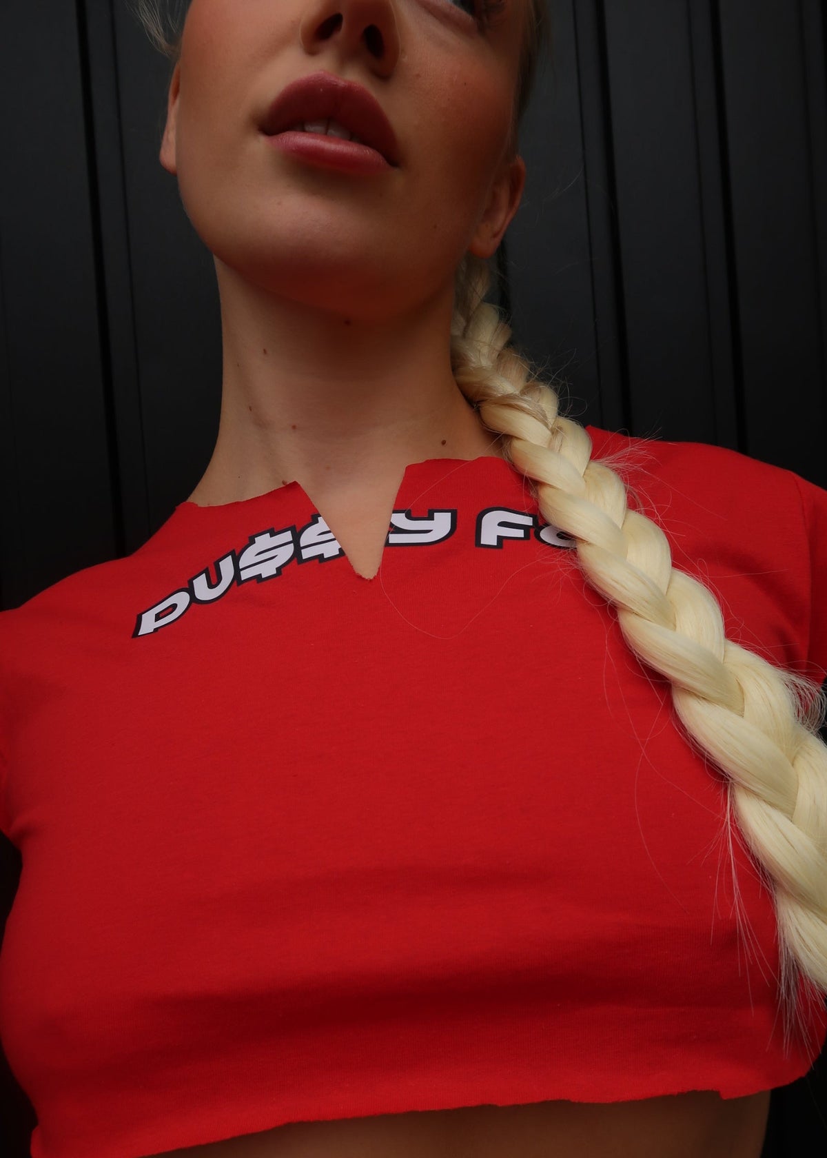 Person wearing a red sweatshirt with a logo, looking to the side.