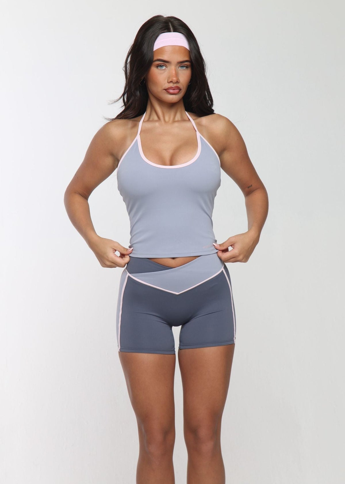 Woman wearing a gray athletic outfit on a white background