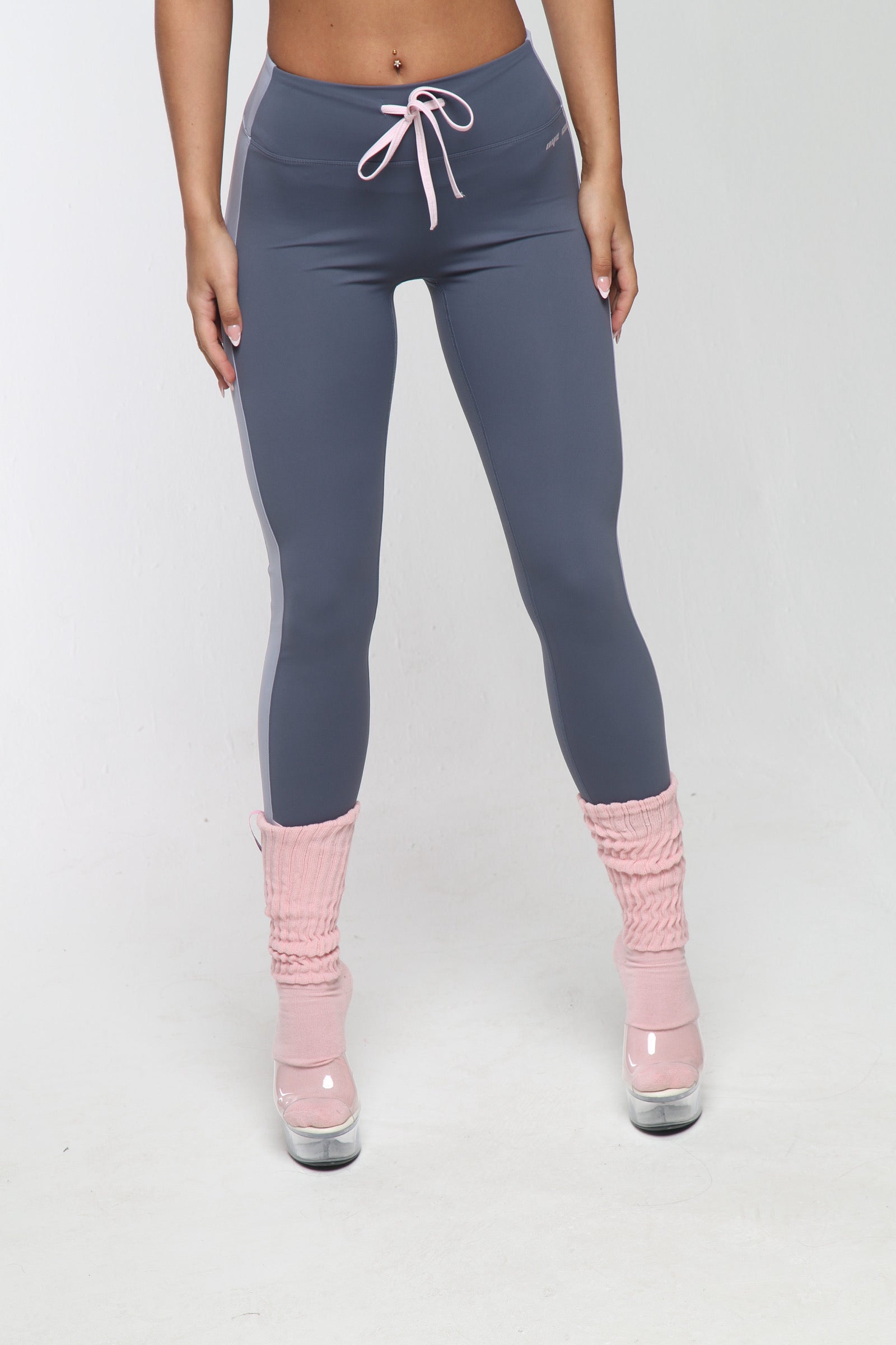 Person wearing gray leggings and pink socks on a white background