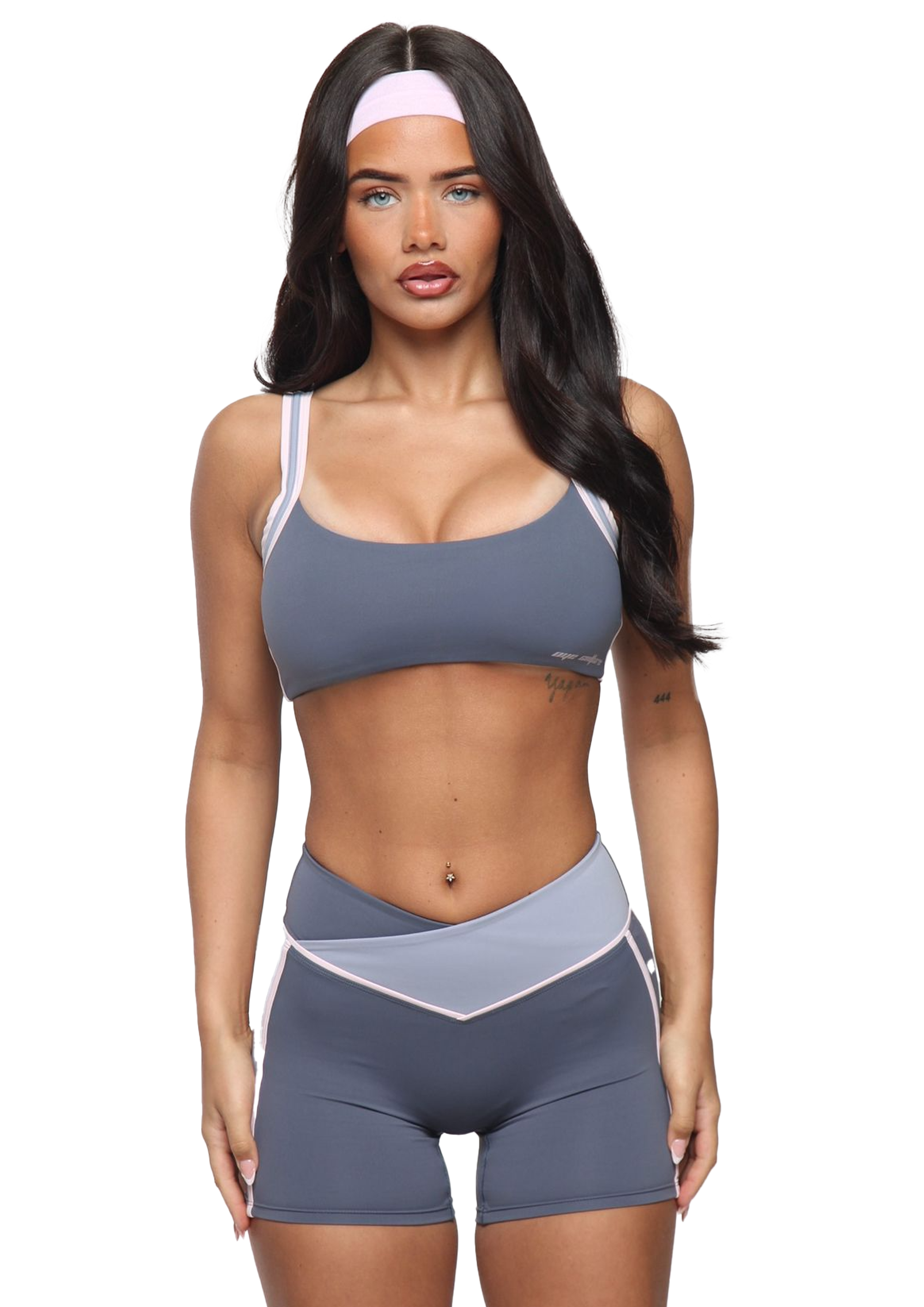 Woman wearing a gray sports bra and shorts set on a white background