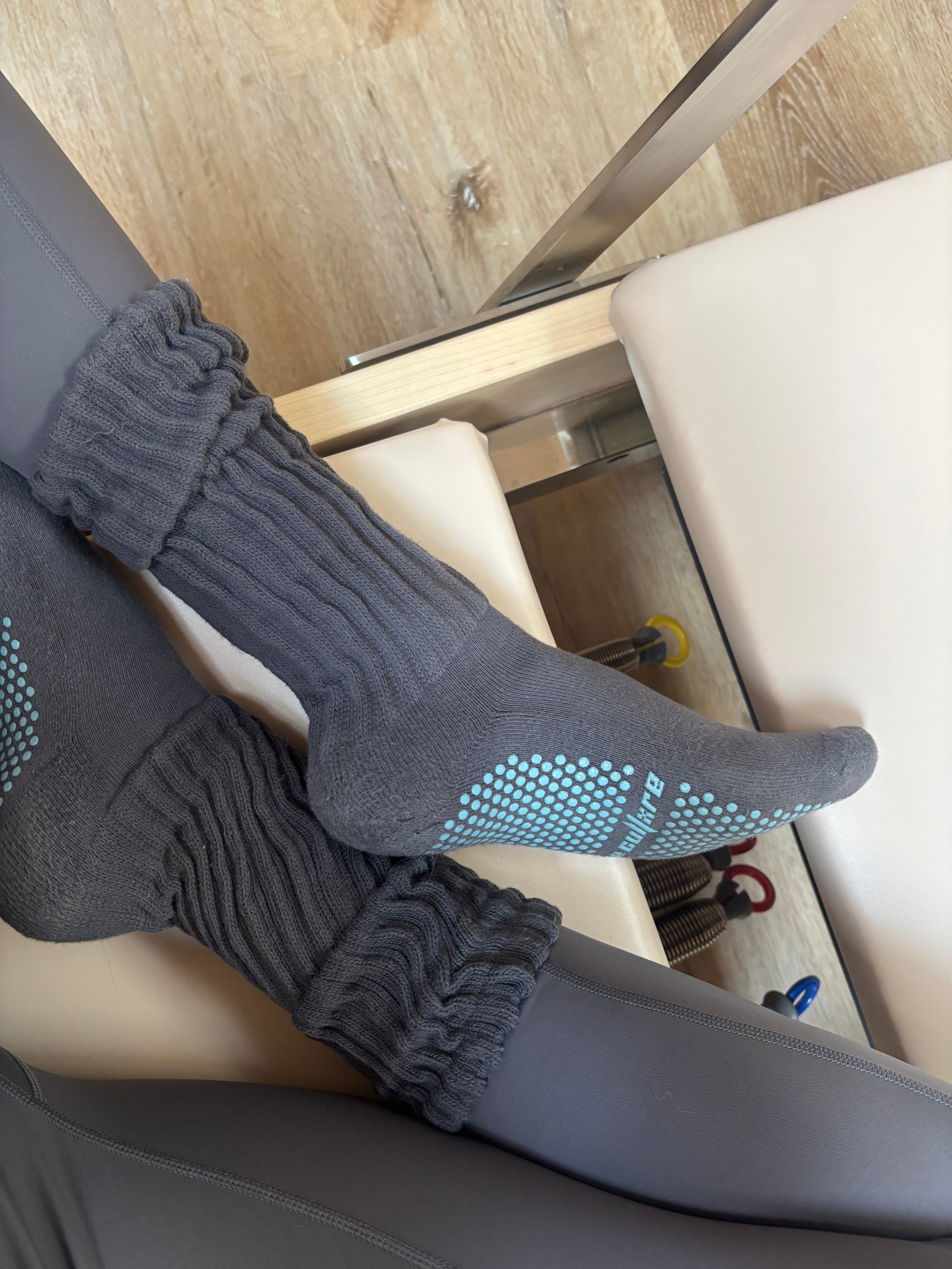 Gray socks with blue grip dots on a chair