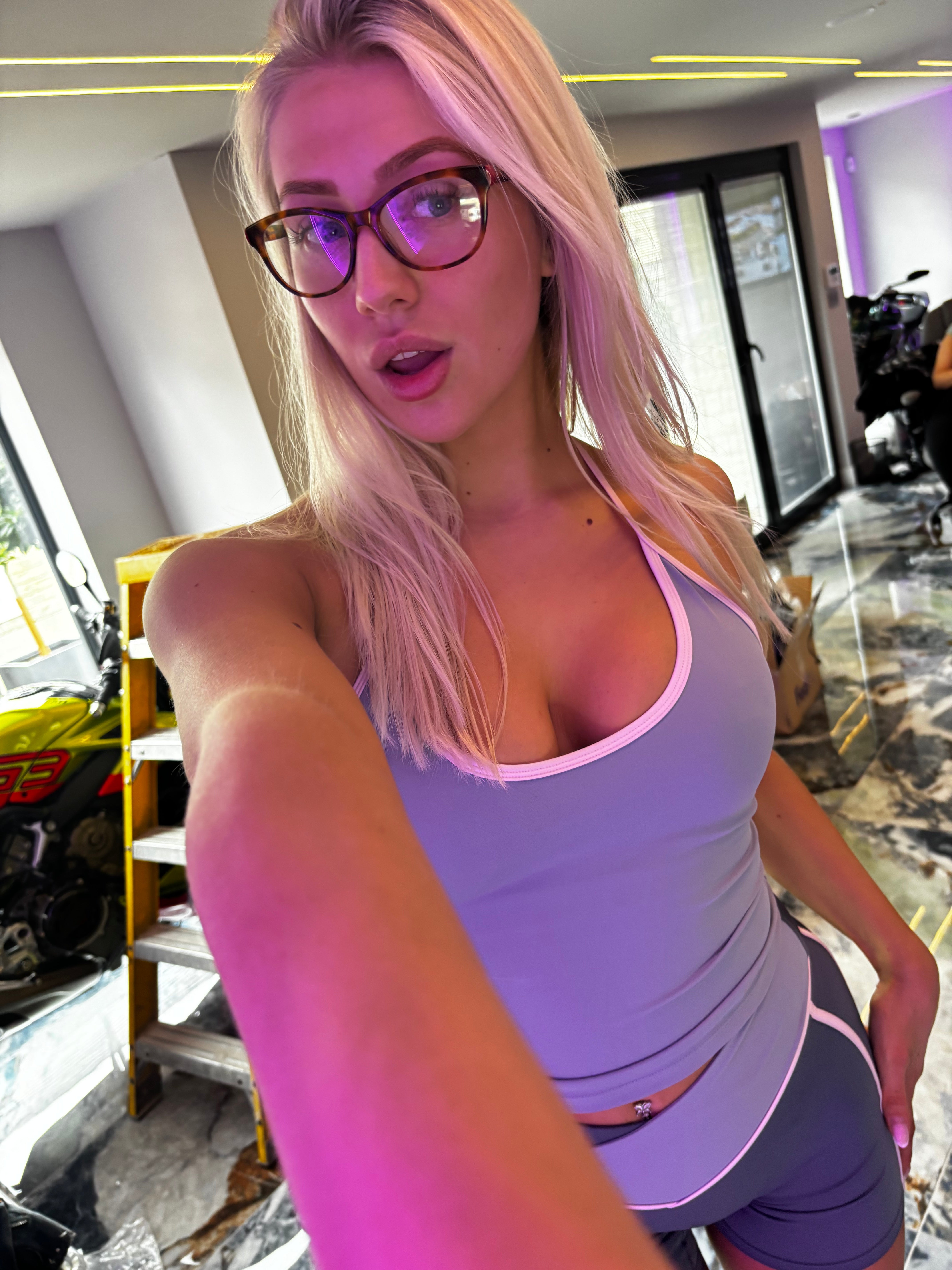 Woman taking a selfie in a modern interior setting with neon lights.