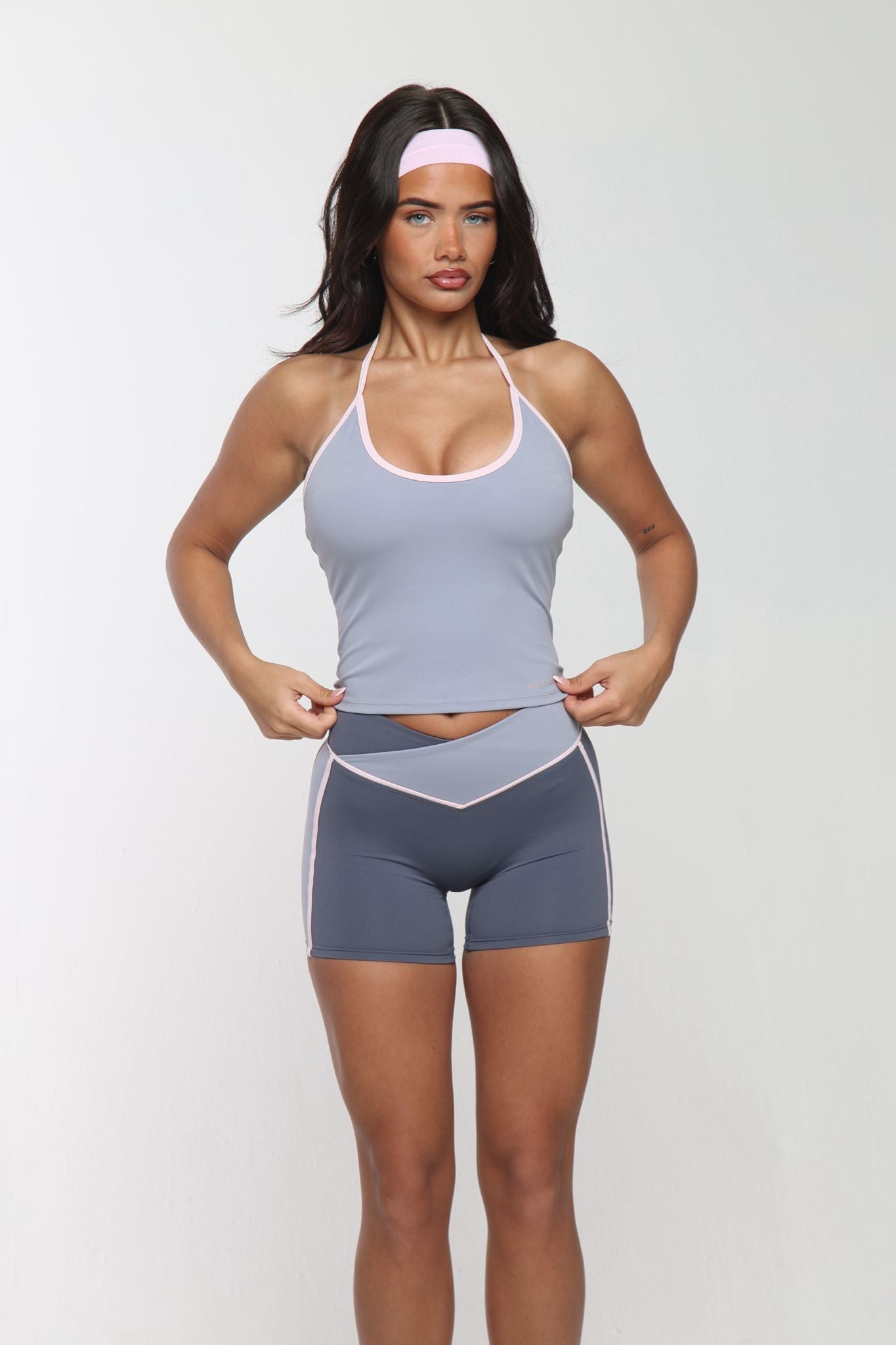 Woman wearing a gray athletic outfit on a white background